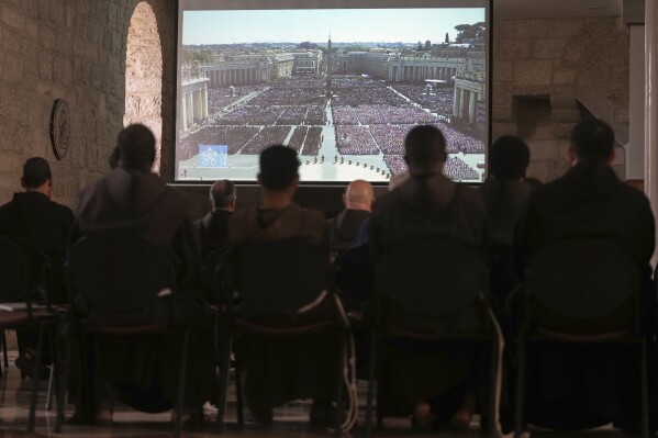 Sacerdotes siguen la transmisión en vivo del funeral del papa Francisco en el Vaticano, en el Convento de San Salvador en Jerusalén, el sábado 26 de abril de 2025. (AP Foto/Mahmoud Illean)