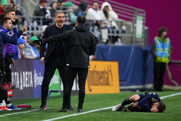 Vancouver Whitecaps coach Vanni Sartini argues with an official as midfielder Ryan Gauld lies on the ground during the first half of the team's MLS soccer match against the Seattle Sounders, Saturday, May 18, 2024, in Seattle. (AP Photo/Lindsey Wasson)
