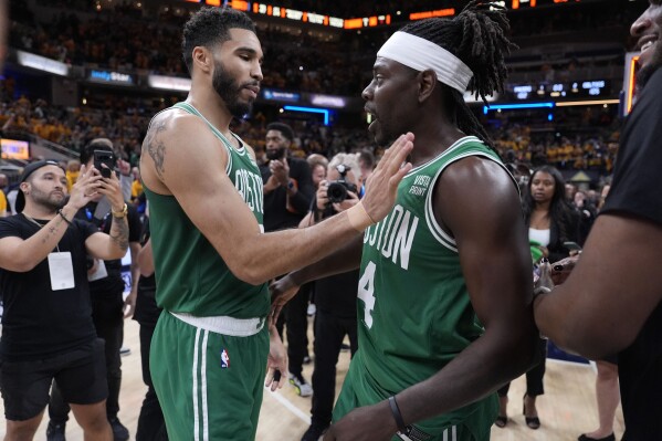 Boston Celtics forward Jayson Tatum, left, celebrates with teammate guard Jrue Holiday (4) after Game 4 of the NBA Eastern Conference basketball finals against the Indiana Pacers, Monday, May 27, 2024, in Indianapolis. The Celtics won 105-102.(AP Photo/Michael Conroy)