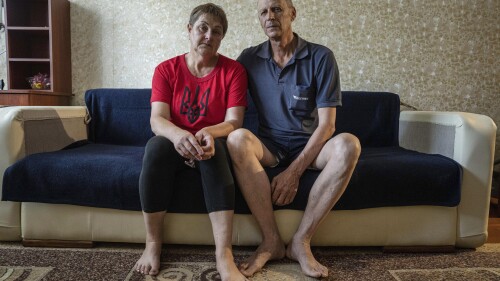 Nataliia Skakun and her husband Serhii, former residents of Oleshky, Ukraine, sit on a sofa at their apartments in Mykolaiv, Ukraine, Tuesday, July 4, 2023. "Young people left, and pensioners stayed," said Skakun, 54, who recently left Oleshky with her husband and resettled in Mykolaiv in the Kherson region. (AP Photo/Evgeniy Maloletka)