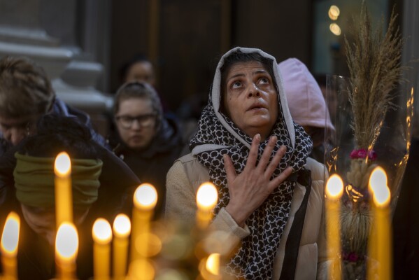 A Lithuanian Orthodox believer prays during the Palm Sunday Mass at the Orthodox Church of the Holy Spirit in Vilnius, Lithuania, Sunday, April 13, 2025. (AP Photo/Mindaugas Kulbis)