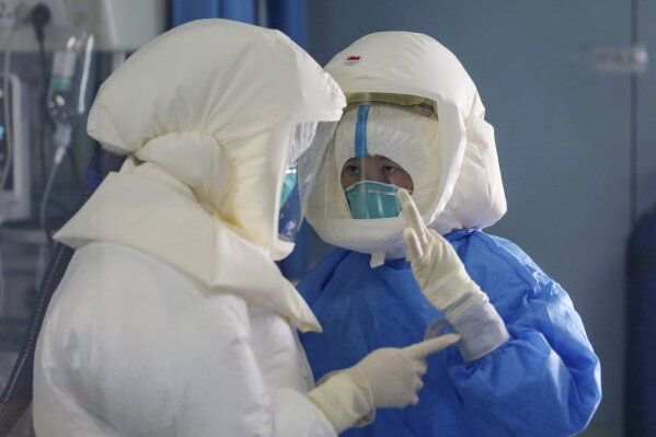 Medical staff work in the negative-pressure isolation ward in Jinyintan Hospital, designated for critical COVID-19 patients, in Wuhan in central China's Hubei province Thursday, Feb. 13, 2020. China on Thursday reported 254 new deaths and a spike in virus cases of 15,152, after the hardest-hit province of Hubei applied a new classification system that broadens the scope of diagnoses for the outbreak, which has spread to more than 20 countries. (Chinatopix Via AP)