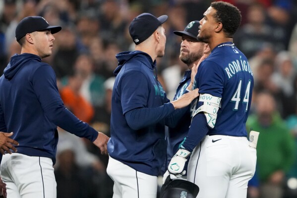 Seattle Mariners' Julio Rodriguez (44) is held back by teammate Bryan Woo, center, as Dylan Moore, left, looks on as benches clear after Rodriguez struck out against Houston Astros relief pitcher Hector Neris during the sixth inning of a baseball game Wednesday, Sept. 27, 2023, in Seattle. (AP Photo/Lindsey Wasson)