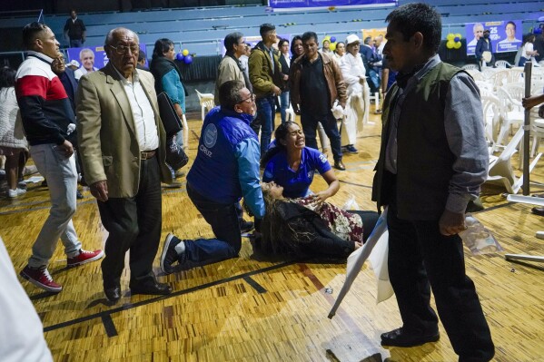 Una mujer simpatizante del candidato presidencial Fernando Villavicencio yace herida tras el ataque por disparos en el que Villavicencio fue asesinado a la salida de un acto electoral en un colegio de Quito, Ecuador, el miércoles 9 de agosto de 2023 2023. (API vía AP)