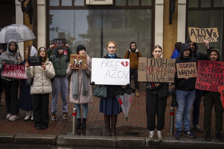 People hold "Free Azov" signs during a rally aiming to raise awareness on the fate of Ukrainian prisoners of war, in Kyiv, Ukraine, Sunday, April 21, 2024. (AP Photo/Francisco Seco)