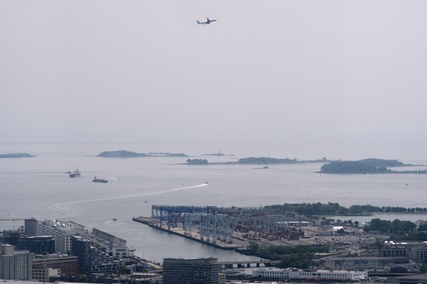 Hazy skies diminish the view of the Boston Harbor Islands, Wednesday, June 4, 2025, in Boston, Mass. (AP Photo/Robert F. Bukaty)