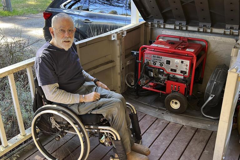 Richard Skaff, a paraplegic who is an advocate for the disabled, talks about his backup generator at home in Guerneville, Calif., on March 9, 2022. He was fortunate to have a generator to keep his electric wheelchair powered and his house heated, but said many others with disabilities live on minimal incomes and struggle to get by during outages. (AP Photo/Terry Chea)