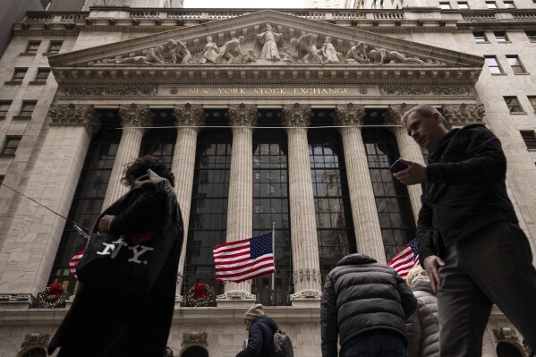 FILE - People walk past the New York Stock Exchange, Dec. 11, 2023, in New York. Just a quarter of business economists and analysts expect the United States to fall into recession in 2024. And any downturn would likely result from an external shock, such as a conflict involving China, rather than from domestic economic factors such as higher interest rates. (AP Photo/Yuki Iwamura, File)