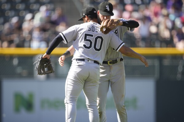 Chicago White Sox second baseman Lenyn Sosa (50) celebrates with shortstop Zach Remillard after a baseball game against the Colorado Rockies, Sunday, Aug. 20, 2023, in Denver. (AP Photo/David Zalubowski)