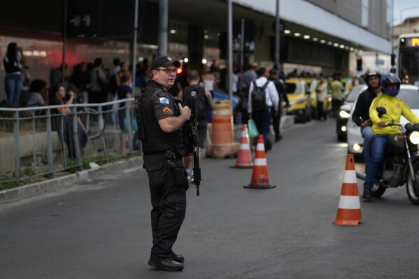 Police patrols outside a bus terminal where police say a gunman wounded two people and took 17 others hostage aboard a bus, in Rio de Janeiro, Brazil, Tuesday, March 12, 2024. (AP Photo/Silvia Izquierdo)