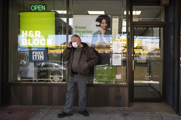 FILE - A man waits outside a H&R Block tax preparation office on Monday, April 6, 2020, in the Brooklyn borough of New York. Tax season is here again. Whether you do your taxes by yourself, go to a tax clinic or hire a professional, navigating the tax system can be complicated. (AP Photo/Mark Lennihan, File)