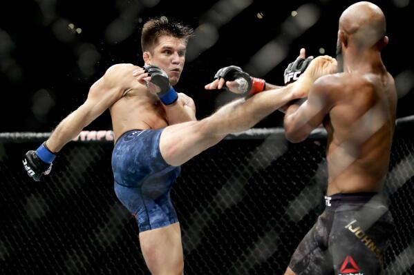 FILE - In this Aug. 4, 2018, file photo, Henry Cejudo, left, kicks Demetrious Johnson during their UFC flyweight title mixed martial arts bout at UFC 227 in Los Angeles. Former two-division world champion Henry Cejudo fights for the bantamweight title bout against reigning champion Aljamain Sterling. The are the main event of UFC 288 on Saturday at the Prudential Center in Newark, N.J. (AP Photo/Chris Carlson, File)