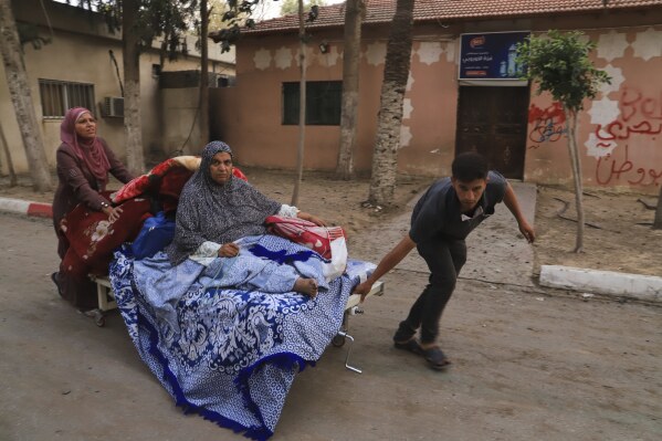 Palestinians evacuate patients from the European hospital in Khan Younis, Gaza, after it was hit by an Israeli army airstrike, Tuesday, May 13, 2025. The Israeli military said it had carried out a strike targeting what it said was a Hamas "command and control center" located beneath the hospital. (AP Photo/Mariam Dagga)
