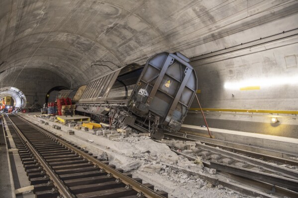 Accident-damaged freight wagons are seen at the scene of the accident in the Gotthard base tunnel near Faido during a media tour at the accident site on Wednesday, Sept. 6, 2023 in Faido in the canton of Ticino. Switzerland’s national rail operator said Thursday, Nov. 2, 2023, the world’s longest rail tunnel won't be fully reopened to train traffic until next September, again pushing back the target date for repairs of damage caused by a cargo train derailment. The Swiss federal railway operator, known by its German-language acronym SBB, said the damage from the Aug. 10 derailment in the Gotthard tunnel, Switzerland’s main north-south rail thoroughfare, is “much more significant than first imagined.” (Urs Flueeler/Keystone via AP)