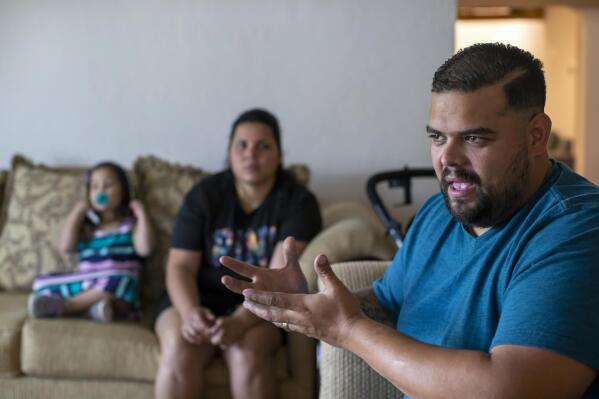 Venezuelan asylum-seeker Luis Lopez speaks with The Associated Press, as his wife, Oriana Marcano, and daughter Amaloha Lopez listen in El Paso, Texas, Friday, May 12, 2023. When Lopez was lost in Panama's Darien Gap last year with his pregnant wife, their two children and her grandmother, he often knelt in the mud to beg God not to abandon them. (AP Photo/Andres Leighton)