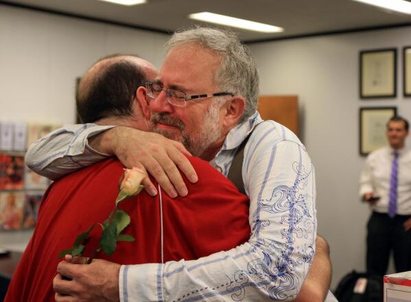 Christopher Brown, left, and Tom Fennell hug after getting their marriage license at the Douglas County County Clerk's office in Omaha, Neb., Friday, June 26, 2015. Gay couples in Nebraska will now have their marriages legally recognized now that the U.S. Supreme Court declared Friday that same-sex couples have a right to marry anywhere in the United States. (AP Photo/Nati Harnik)