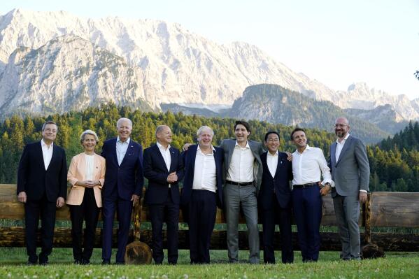 Members of the G7 from left, Prime Minister of Italy Mario Draghi, European Commission President Ursula von der Leyen, President Joe Biden, German Chancellor Olaf Scholz, British Prime Minister Boris Johnson, Canadian Prime Minister Justin Trudeau, Prime Minister of Japan Fumio Kishida, French President Emmanuel Macron and European Council President Charles Michel stand for a photo at Schloss Elmau following their dinner at G7 Summit in Elmau, Germany, Sunday, June 26, 2022. The bench behind them became famous when former German Chancellor Angela Merkel and former President Barack Obama were photographed talking by it. (AP Photo/Susan Walsh)