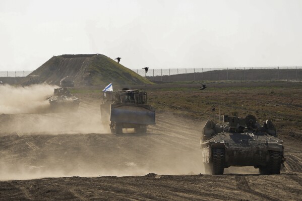 Israeli troops move near the Gaza Strip border in southern Israel, Monday, March 4, 2024. The army is battling Palestinian militants across Gaza in the war ignited by Hamas' Oct. 7 attack into Israel. (AP Photo/Ohad Zwigenberg, File)