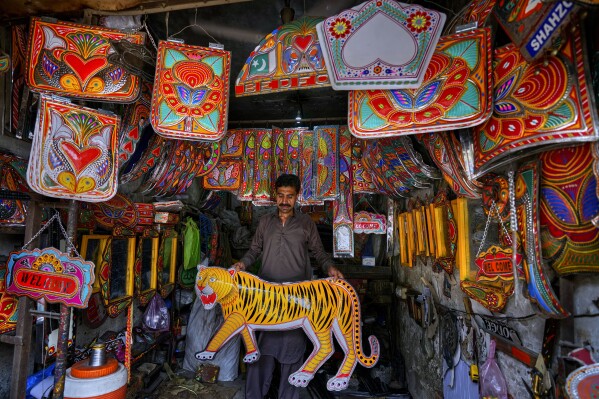 A vendor displays metal pieces painted in the style of traditional art used to decorate trucks at a shop in Rawalpindi, Pakistan, on Saturday, April 19, 2025. (AP Photo/Anjum Naveed)