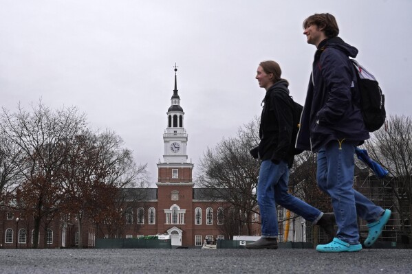 FILE - Students cross the campus of Dartmouth College, March 5, 2024, in Hanover, N.H. While tax pros say it's great for college students to start filing their own forms, parents and students should double-check everything carefully before anyone pushes the "submit" button. (Ǻ Photo/Robert F. Bukaty, File)