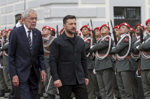Ukraine's President Volodymyr Zelenskyy, right, and Austrian President Alexander van Der Bellen walk past the honour guard in Vienna, Austria, Monday, June 16, 2025. (AP Photo/Heinz-Peter Bader)