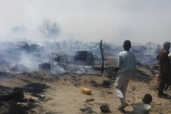 
              ADVANCE FOR PUBLICATION ON WEDNESDAY, FEB. 13, AND THEREAFTER - In this photo taken Thursday, Feb. 7, 2019, and provided by the International Rescue Committee (IRC), internally-displaced persons look at destroyed houses following a fire at a camp for those who had fled fighting in surrounding areas, in Monguno town, Borno State, northeastern Nigeria. Nigeria's government acknowledges an extremist resurgence by Boko Haram offshoot in the Islamic State West Africa Province, and the renewed extremist violence may threaten the validity of upcoming Saturday's election in the northeast. (Deborah Peter/International Rescue Committee via AP)
            