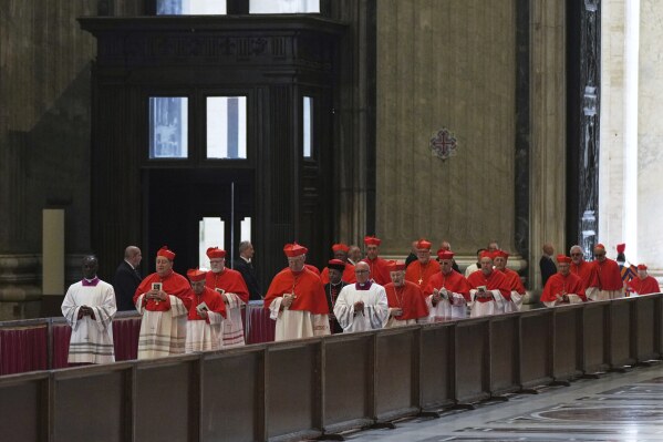 Cardinal's in the procession with the body of Pope Francis, who will lie in state for three days, enter St. Peter's Basilica at the Vatican, Wednesday, April 23, 2025. (AP Photo/Francisco Seco)