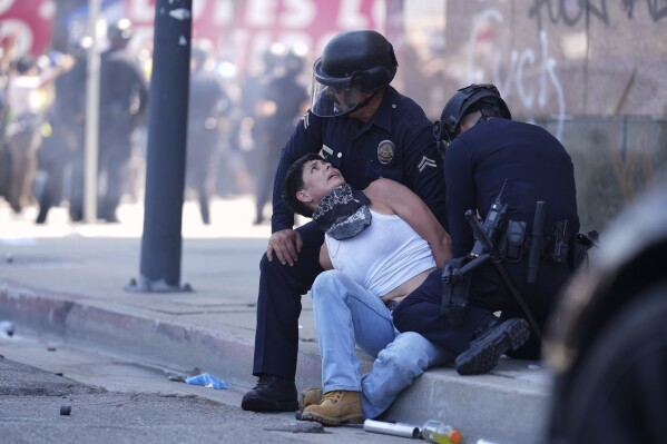 A protestor is detained in downtown Los Angeles, Sunday, June 8, 2025, following last night's immigration raid protest. (AP Photo/Eric Thayer)