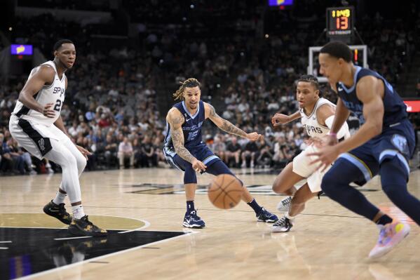 Memphis Grizzlies' Brandon Clarke (15) passes to teammate Desmond Bane, right, between San Antonio Spurs' Romeo Langford and Charles Bassey, left, during the second half of an NBA basketball game, Wednesday, Nov. 9, 2022, in San Antonio. The Grizzlies won 124-122 in overtime. (AP Photo/Darren Abate)