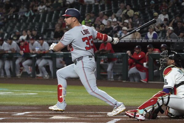 Washington Nationals' Nathaniel Lowe hits an RBI double against the Arizona Diamondbacks in the first inning during a baseball game, Saturday, May 31, 2025, in Phoenix. (AP Photo/Rick Scuteri)