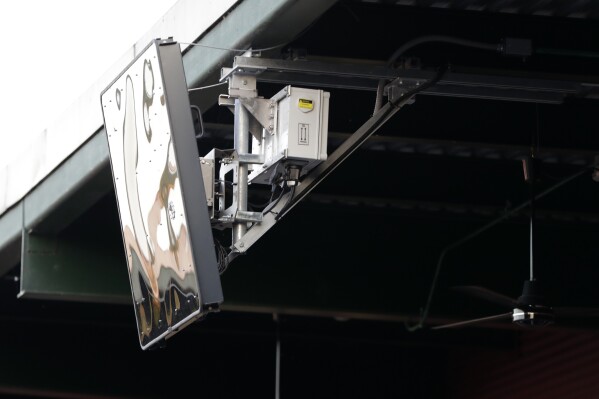 FILE - A radar device is mounted on the roof behind home plate at PeoplesBank Park during the third inning of the Atlantic League All-Star minor league baseball game in York, Pa., July 10, 2019. Major League Baseball started experimenting with robots calling balls and strikes in the independent Atlantic League in 2019 and used the computer at Low-A in 2021. (AP Photo/Julio Cortez, File)