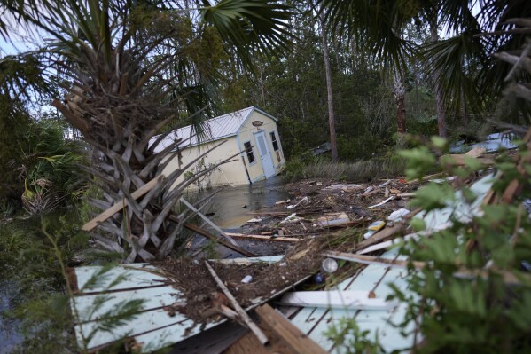 A displaced building sits alongside flooding littered with debris from other buildings, in Horseshoe Beach, Fla., after the passage of Hurricane Idalia, Wednesday, Aug. 30, 2023. (AP Photo/Rebecca Blackwell)