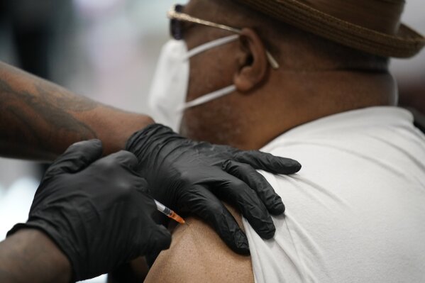 David Williams receives a COVID-19 vaccine at the Martin Luther King Senior Center, Wednesday, Feb. 10, 2021, in North Las Vegas. The makers of COVID-19 vaccines are figuring out how to tweak their recipes against worrisome virus mutations — if and when the shots need an update. (AP Photo/John Locher, File)