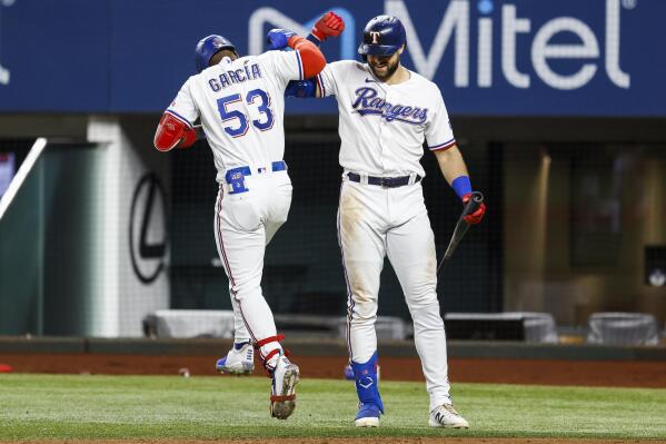 Texas Rangers' Adolis Garcia (53) is congratulated by Joey Gallo after hitting a solo home run during the sixth inning of a baseball game against the Oakland Athletics, Wednesday, June 23, 2021, in Arlington, Texas. (AP Photo/Brandon Wade)