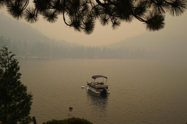 Smoke from the Caldor Fire, shrouds Fallen Leaf Lake near South Lake Tahoe, Calif., Tuesday, Aug. 24, 2021. The massive wildfire, that is over a week old, has scorched more than 190 square miles, (492 square kilometers) and destroyed hundreds of homes since Aug. 14. It is now less than 20 miles from Lake Tahoe. (AP Photo/Rich Pedroncelli)