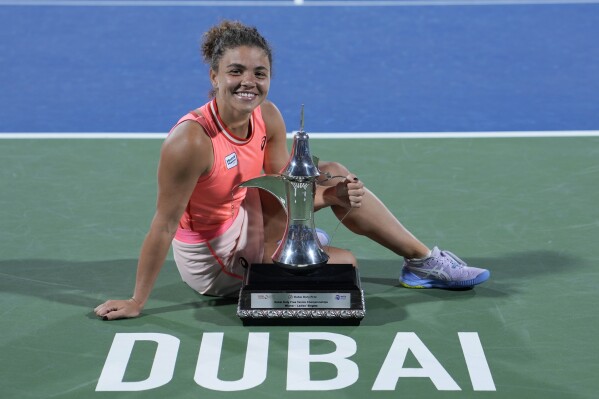 Jasmine Paolini of Italy poses for a photograph with her trophy after she beats Anna Kalinskaya during their final match of the Dubai Duty Free Tennis Championships against in Dubai, United Arab Emirates, Saturday, Feb. 24, 2024. (AP Photo/Kamran Jebreili)