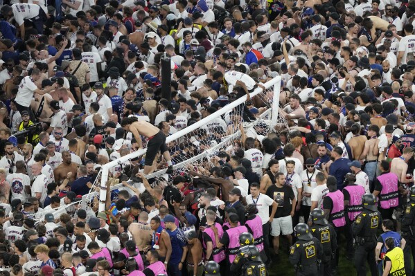 Fans of PSG invade the pitch after the Champions League final soccer match between Paris Saint-Germain and Inter Milan at the Allianz Arena in Munich, Germany, Saturday, May 31, 2025. (AP Photo/Michael Probst)