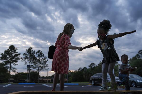Worshippers leave a church service in Palatka, Fla., Wednesday, April 14, 2021. Palatka, with a population split almost equally between Black and white, had been devastated by the 2008 Great Recession. (AP Photo/David Goldman)