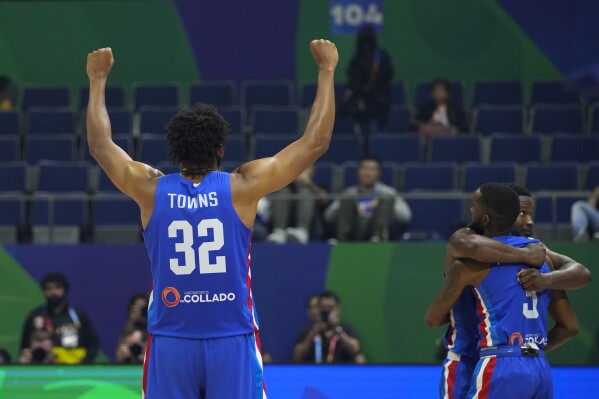 Dominican Republic forward Karl-Anthony Towns (32) and teammates celebrate after winning against Angola during their Basketball World Cup group A match at the Araneta Coliseum, Manila, Philippines on Tuesday, Aug. 29, 2023. (AP Photo/Aaron Favila)