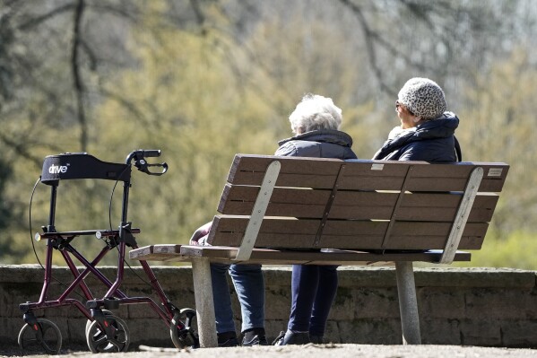 FILE - Elderly women sit on a bench beside their walker in the sun at a park in Gelsenkirchen, Germany, Wednesday, April 5, 2023. Germany's Cabinet on Wednesday, April 24, 2024, approved a 4.57% rise in retirees' pensions from this summer, an increase that is well above the current rate of inflation. (AP Photo/Martin Meissner, File)