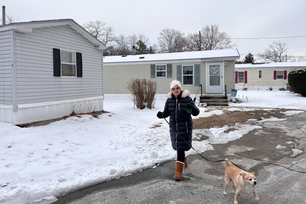 Ann Urbanovitch walks through her mobile home park on Jan. 23, 2024, in Auburn, Mass., where residents complain they are facing double-digit rent increases that they cannot afford. Monthly rent has outpaced income across the U.S., and forced many to make tough decisions between everyday necessities and a home. In turn, a record number of people are becoming homeless and evictions filings have ratcheted up as pandemic-era eviction moratoriums and federal assistance ends. (AP Photo/Michael Casey)