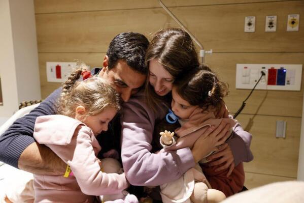 Aviv Asher, de 2,5 años, su hermana Raz Asher, de 4,5 años, y su madre Doron, reaccionan cuando se reúnen con Yoni, el esposo de Doron y su padre, después de su regreso a Israel al complejo designado en el Centro Médico Infantil Schneider el viernes. 24 de noviembre de 2023. El viernes comenzó el alto el fuego de cuatro años de días en la guerra entre Israel y Hamás en Gaza con el intercambio de rehenes y prisioneros.  (Centro Médico Infantil Schneider vía AP)