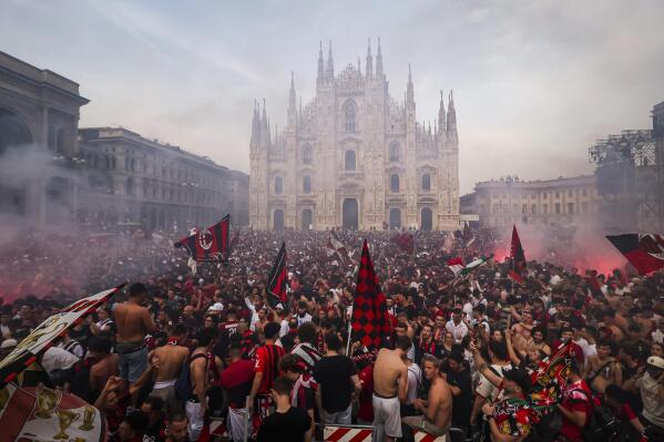 AC Milan fans celebrate in Piazza Duomo square after a Serie A soccer match between Sassuolo and AC Milan, being played in Reggio Emilia, in Milan, Italy, Sunday, May 22, 2022. AC Milan secured its first Serie A title in 11 years on Sunday with a 3-0 win at Sassuolo. (Alessandro Bremec/LaPresse via AP)