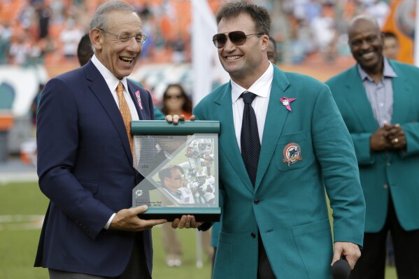 FILE - Former Miami Dolphins player Zach Thomas is honored by managing general partner, Stephen Ross, left, during half time of an NFL football game against the St. Louis Rams in Miami, in this Sunday, Oct. 14, 2012, file photo. Zach Thomas enjoyed a 13-year NFL career that included seven Pro Bowls, five All-Pro selections and the fifth-most tackles in NFL history, and in 2023, his 10th year of eligibility, Thomas will be enshrined into the Pro Football Hall of Fame. (AP Photo/Lynne Sladky, File)