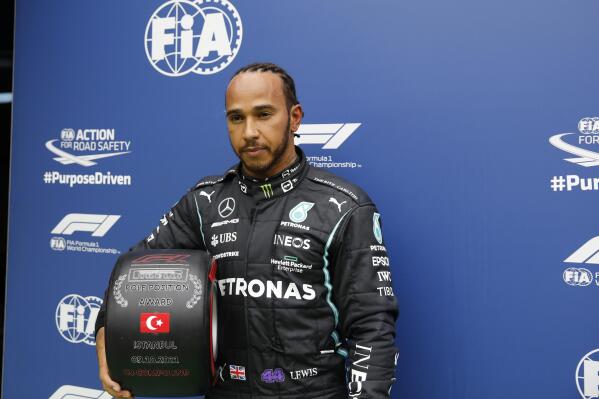 Mercedes driver Lewis Hamilton of Britain, with his award for winning pole position after the end of qualifying for Sunday's Formula One Turkish Grand Prix at the Intercity Istanbul Park circuit in Istanbul, Turkey, Saturday, Oct. 9, 2021. Hamilton who took pole position will start 10th due to a penalty with Mercedes driver Valtteri Bottas of Finland who came second promoted to pole, for the race. (Umit Bektas/Pool Photo via AP)