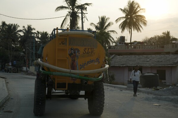 Water leaks from a private tanker en route to deliver the potable water to customers of a residential area in Bengaluru, India, Monday, March 11, 2024. Water levels are running desperately low, particularly in poorer regions, resulting in sky-high costs for water and a quickly dwindling supply. (AP Photo/Aijaz Rahi)
