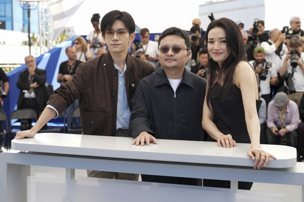 Jackson Yee, from left, director Bi Gan and Shu Qi pose for photographers at the photo call for the film "Resurrection" at the 78th international film festival in Cannes, southern France, Friday, May 23, 2025. (AP Photo/Natacha Pisarenko)