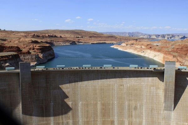FILE - The Glen Canyon Dam is seen, Aug. 21, 2019, in Page, Ariz. Plumbing problems at Glen Canyon Dam, the dam holding back the second-largest reservoir in the U.S., are spurring concerns about future water delivery issues to Southwestern states supplied by the Colorado River. (AP Photo/Susan Montoya Bryan, File)