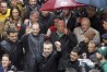Portuguese caretaker Prime Minister Antonio Costa holds an umbrella with the party symbol, while Socialist Party leader Pedro Nuno Santos, in the foreground, raises his fist during an election campaign street action in Lisbon, Friday, March 8, 2024. Portugal is holding an early general election on Sunday when 10.8 million registered voters elect 230 lawmakers to the National Assembly, the country's Parliament. (AP Photo/Joao Henriques)