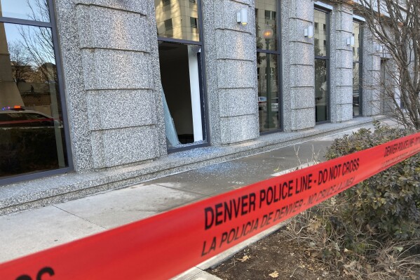 Police tape blocks the damage to large windows at the Colorado Supreme Court on Tuesday, Jan. 2, 2024 in Denver. Authorities say a man inflicted "extensive damage" to the building housing. (AP Photo/Colleen Slevin)